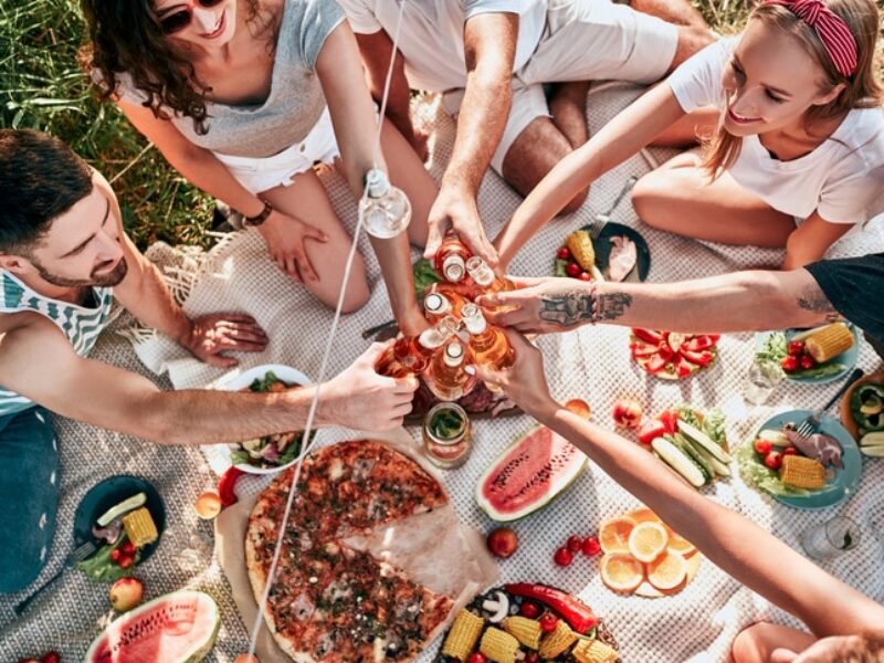 Freunde picknicken zusammen auf einer Wiese