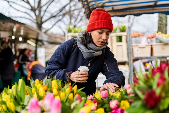 Ein junge Frau kauft Blumen auf einem Markt Trier-Saarburg