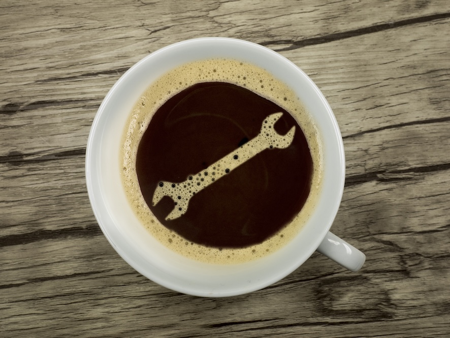Schraubenschlüssel im Schaum einer Kaffeetasse